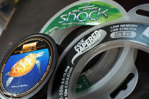 Wybór odpowiedniej plecionki na karpia to klucz do sukcesu. Na zdjęciu widać różne przypony, m.in. Fox Tapered Mono Leaders i PB Products Shield.
