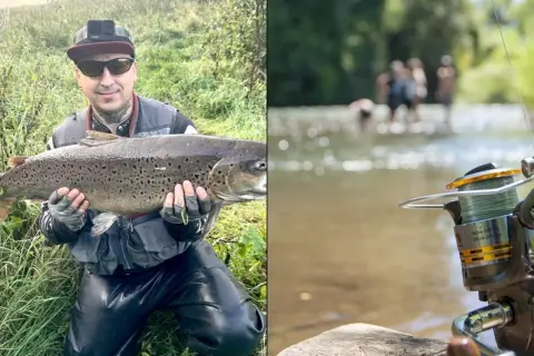 Wędkarz z dumą prezentuje imponującą rybę, być może płoć rekord polski. W tle widać rzekę i ludzi.