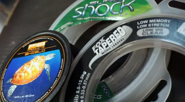 Wybór odpowiedniej plecionki na karpia to klucz do sukcesu. Na zdjęciu widać różne przypony, m.in. Fox Tapered Mono Leaders i PB Products Shield.